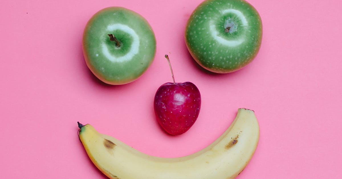 Why is an Apple product used by the villain in London Has Fallen? - Top view of fresh ripe banana and green and red apples arranged as smile on pink background