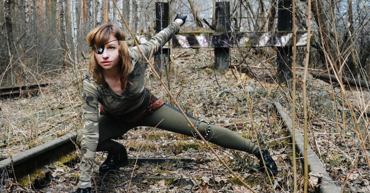 Why is Deadshot refered to as the greatest assassin in the DC universe? - Confident young female soldier in camouflage and eye patch sitting on railway in autumnal woods