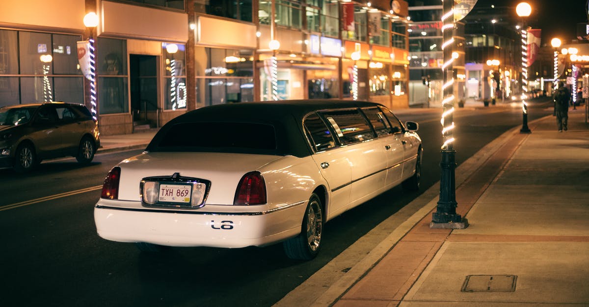Why is Edward in a white limousine at the end of the film? - White limo with tinted glasses and license plate on roadway against buildings illuminated by street lights in evening city