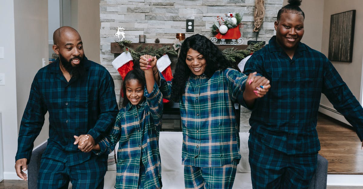Why is Eve so sure about Father Kinley going to hell? - Cheerful African American family smiling happily while holding hands in room with Christmas decorations
