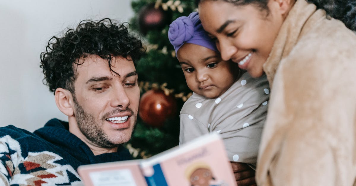 Why is Eve so sure about Father Kinley going to hell? - Happy African American mother and ethnic father reading book to little black daughter near decorated tree during Christmas celebration at home