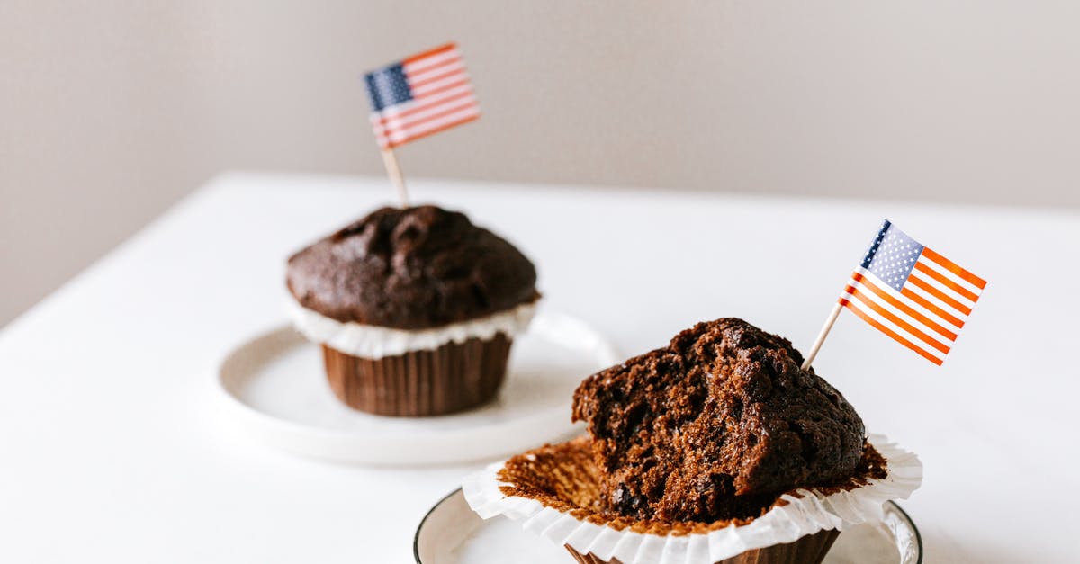 Why is Independence Day: Resurgence not released on July 4th? - From above of bitten and whole festive chocolate cupcakes decorated with miniature american flags and placed on white table