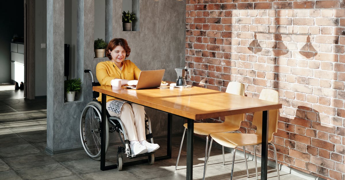 Why is Jake using a regular wheelchair in the year 2154? - Woman Sitting on Wheelchair While Using Laptop