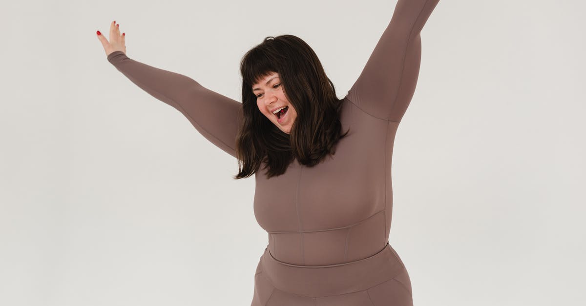 Why is Joy intact while Bing Bong fades away? - Cheerful young plus size female model with dark hair in activewear yelling happily while standing in white studio with raised arms