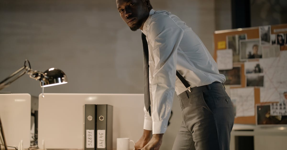 Why is "double-sleeving" a crime in Altered Carbon? - Man Wearing White Long Sleeves Standing Near Work Desk