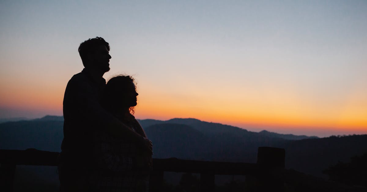 Why is the expiry date revealed in 'Hang the DJ' even though only one side "pressed the button"? - Side view of anonymous couple hugging near rough rocky mountains under clear cloudless sunset