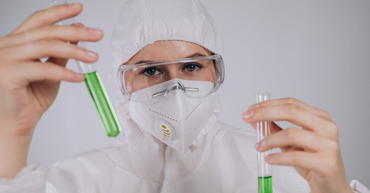 Why is the scientist kidnapped and brainwashed? - A Person Wearing Personal Protective Equipment Holding Test Tubes
