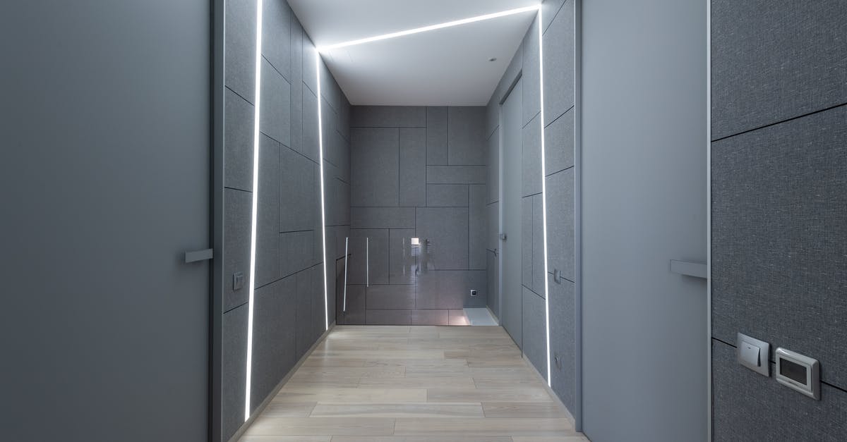 Why is there a switch inside the incinerator? - Interior of contemporary hallway of creative space with parquet and gray walls with doors and modern bright illumination on ceiling and walls