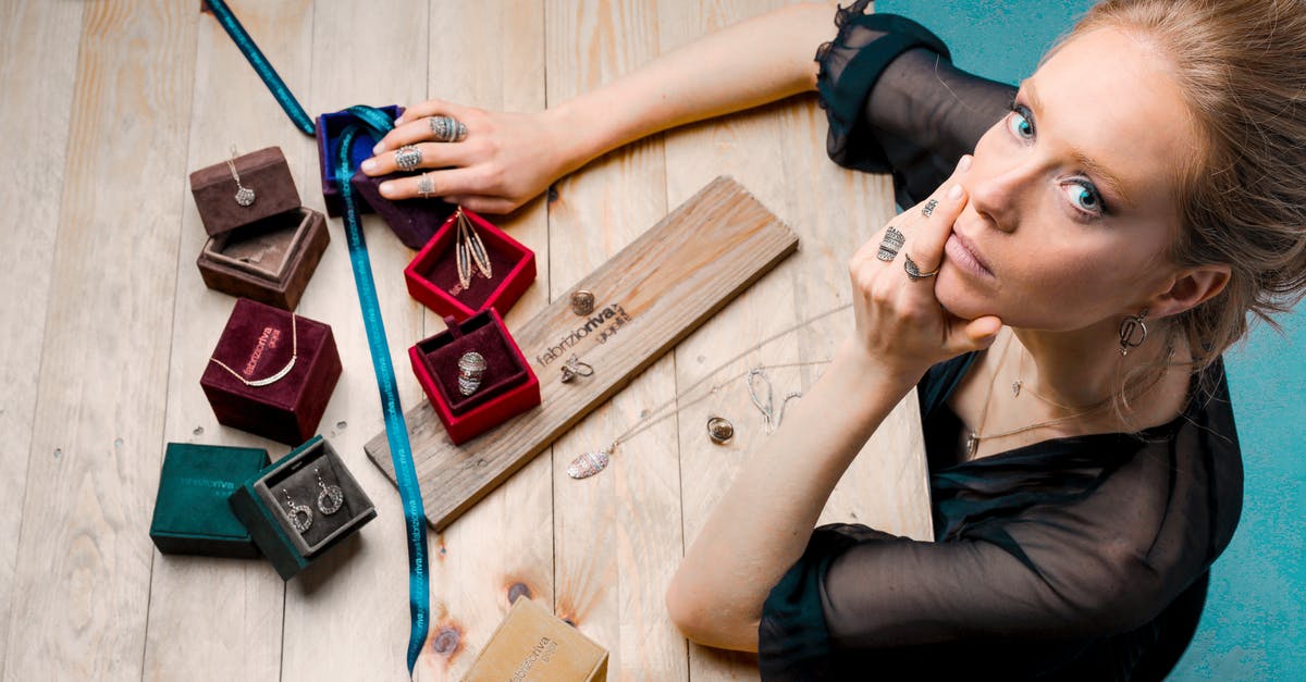 Why is this music box given a prominent role in the credits scene? - From above serious businesswoman looking up at camera while sitting at wooden table with small jewelry boxes with bijouterie and decorating with ribbon as present