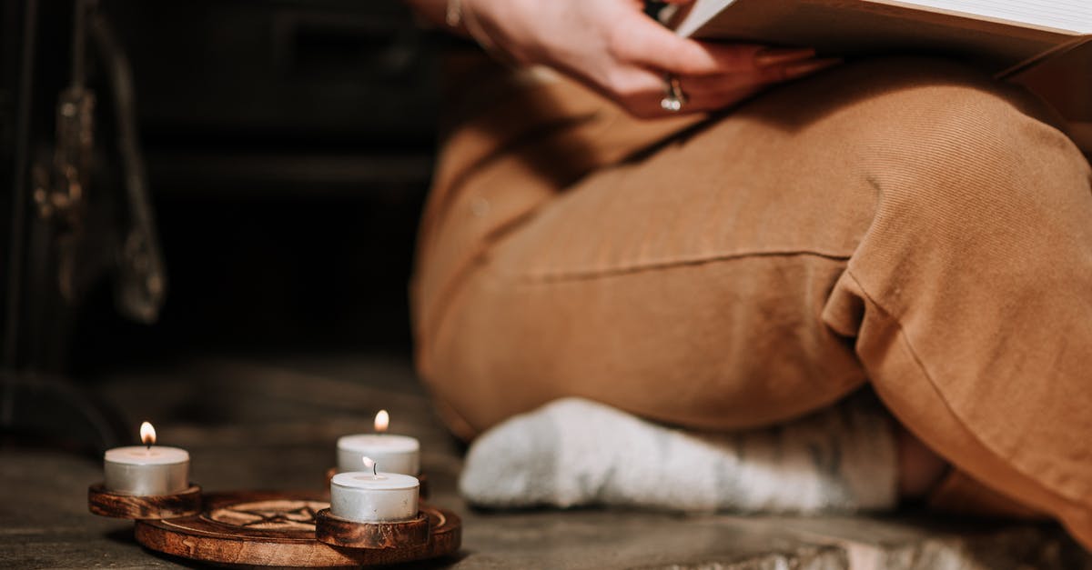 Why isn't there a Power Book I? - Unrecognizable mysterious female with book sitting in aged house near small burning candles placed on metal surface with spiritual symbol