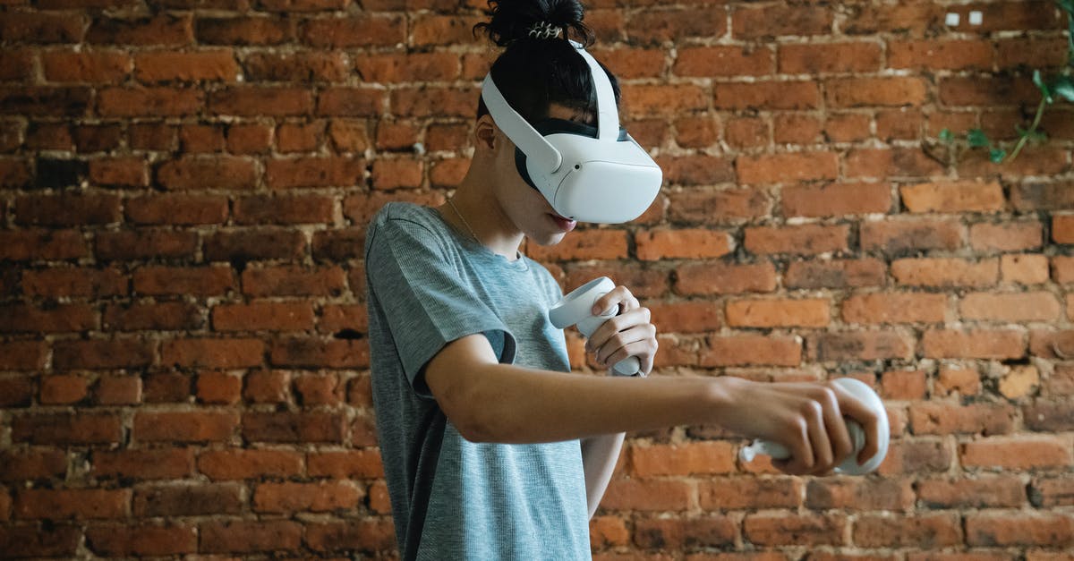 Why isn't there much futuristic technology in Logan? - Side view of teen boy in t shirt with VR headset and controllers playing game near brick wall