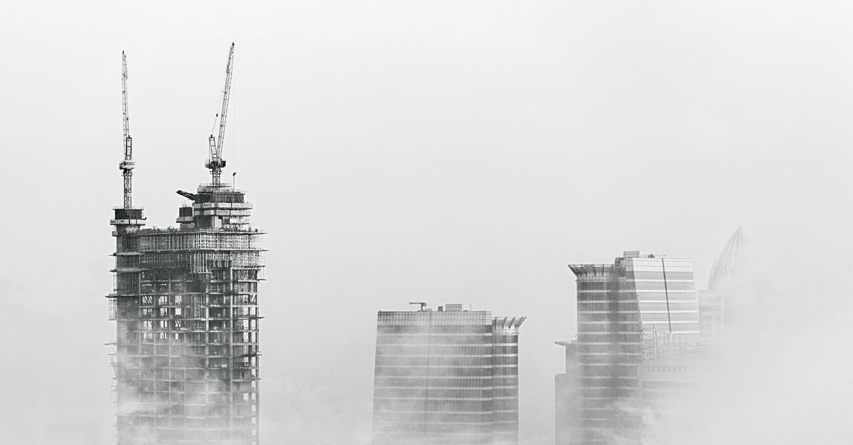 Why there are construction cranes on apparently completed buildings in New York? - Photo of Skyscrapers Surrounded With Clouds