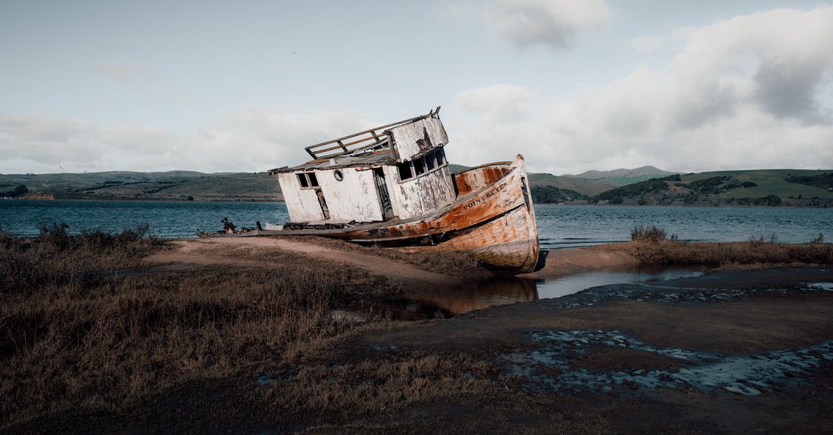 Why was it better to abandon the boat? - White and Rusty Boat on Seashore