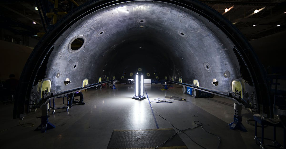 Why was Klaatu unsure about his own spaceship controls? - Illuminated tunnel with rocket construction equipment and lights in dark contemporary spacious industrial factory