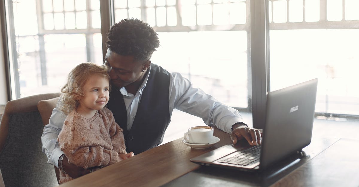 Why was the demon after the little girl? - Cheerful young African American man looking after little girl in cafe using laptop