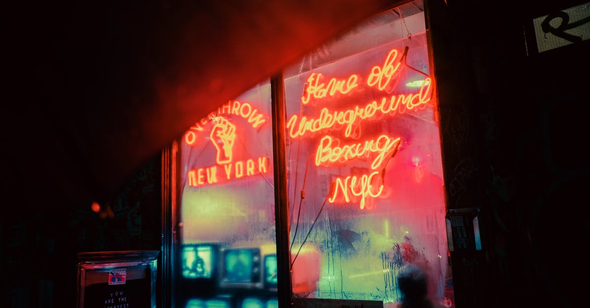 Why was the title changed to Dark Kingdom in the German release? - Exterior of shop with shiny neon inscriptions and vintage TV sets on street in late evening