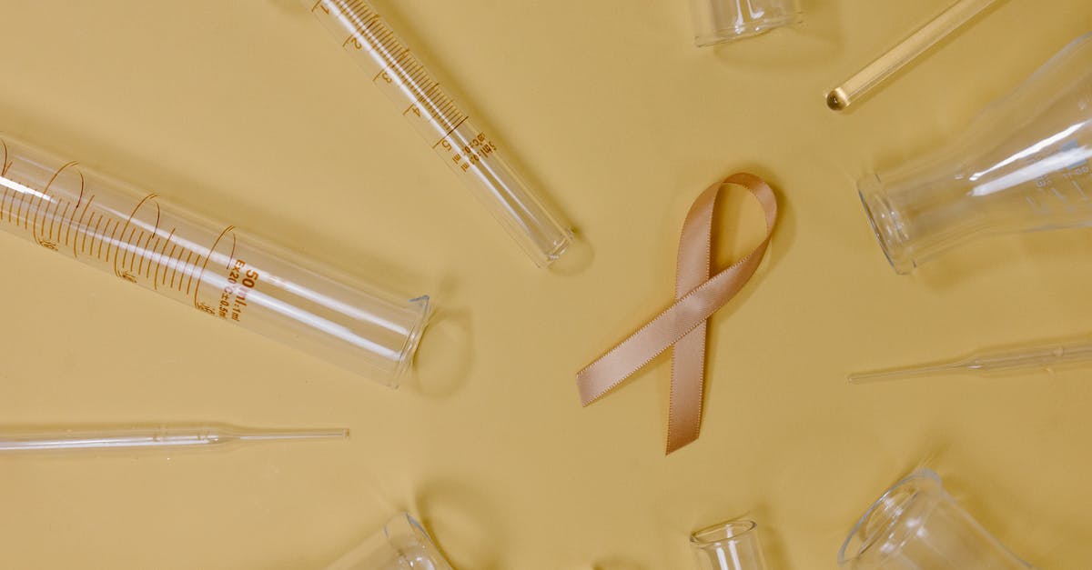 Why was Wuntch not aware of Holt being gay? - Top view of pink ribbon representing cancer placed on yellow background among glass test tubes and flasks in light studio