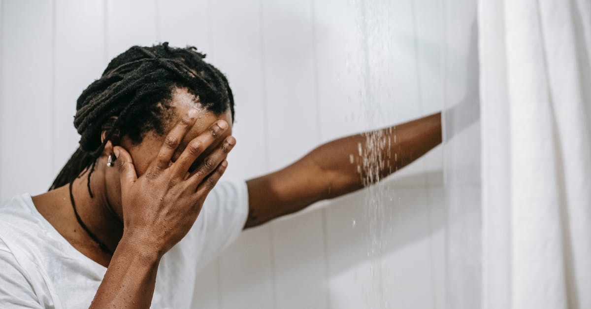 Why wasn't Vincent more furtive in the bathroom? - Sad African American man covering face with hand in shower cabin