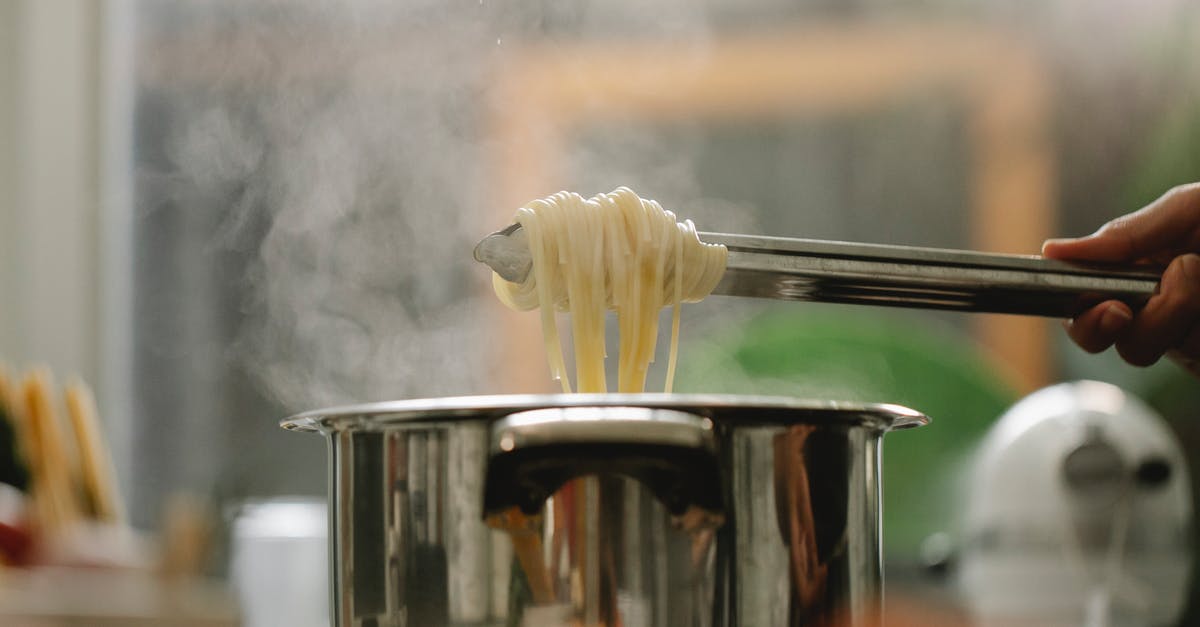 Why were Edward, Henry and Toby dropped from the steam team? - Low angle of crop anonymous chef taking spaghetti from pan with boiling steaming water