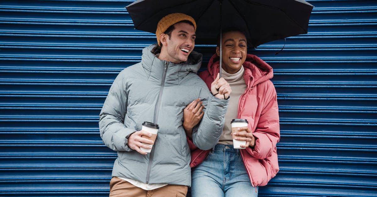 Why were sam and lilith going to have sex? - Happy multiracial couple with umbrella in warm outerwear laughing while standing on street with takeaway beverages in cold rainy weather