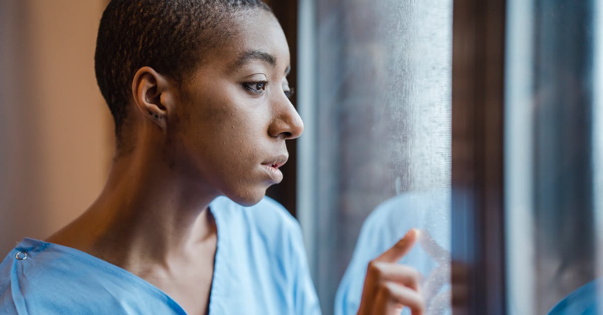 Why would someone think that taking formerly catatonic patients to a museum cause a problem for them? - Melancholic black woman looking at window in clinic