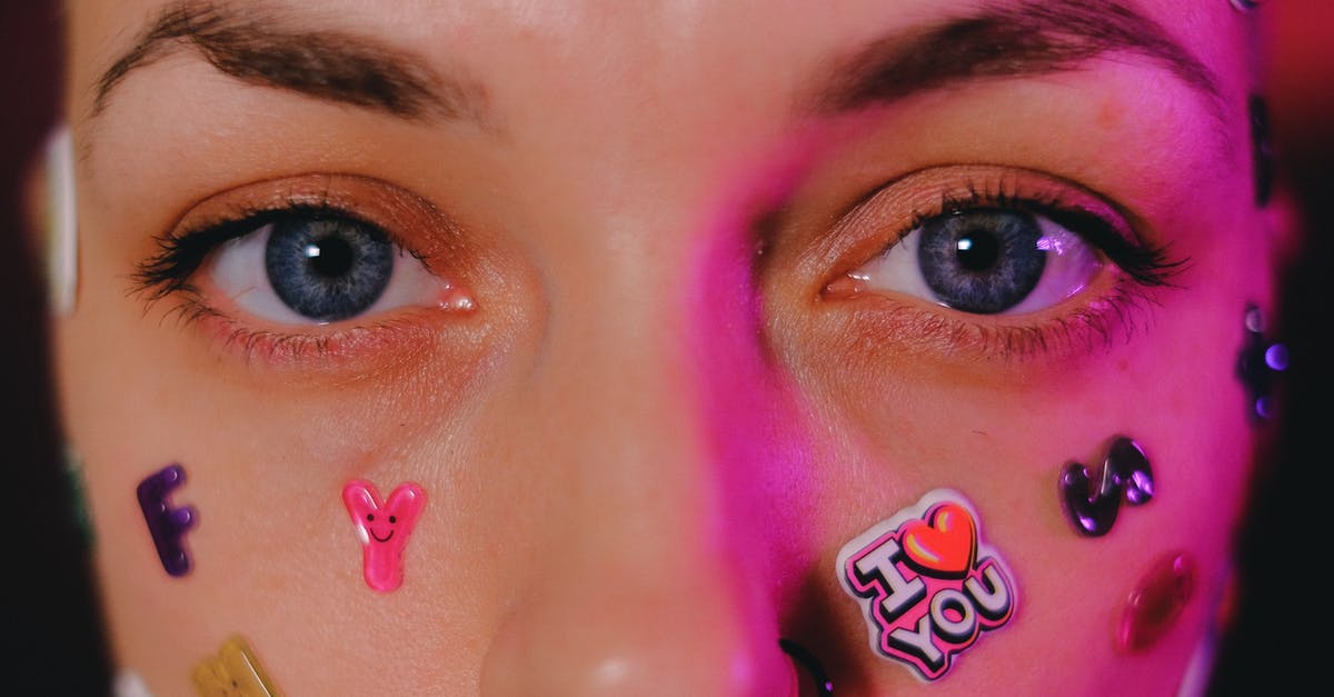 Woody Allen's weird framing in Everyone Says I Love You - Crop calm female with nose piercing and letter stickers on face standing on dark background and looking at camera