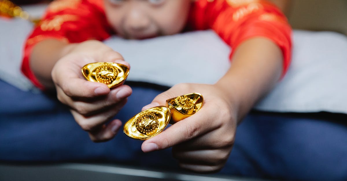Wouldn't Thaddeus Bradley having all of the money stuffed into his car demonstrate his innocence? - Crop happy little Asian boy lying on bed and demonstrating traditional sycee gold ingots during celebration of Chinese New Year