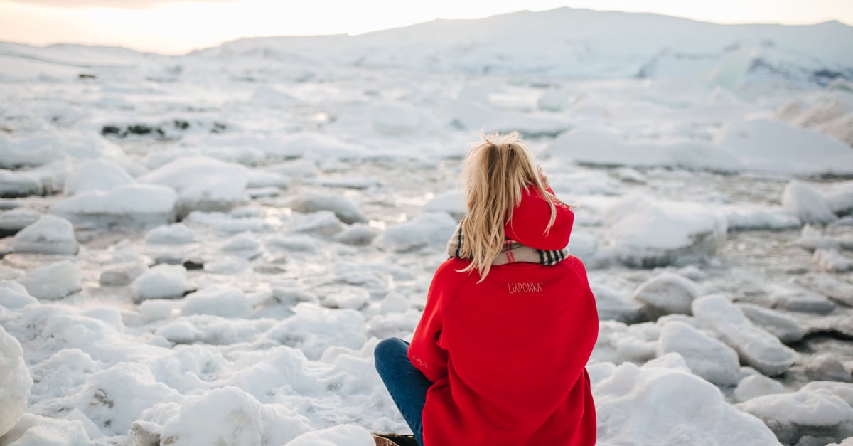 Year on Linda McFly's sweatshirt - A Woman in Red Hoodie Sitting on Snow Covered Ground