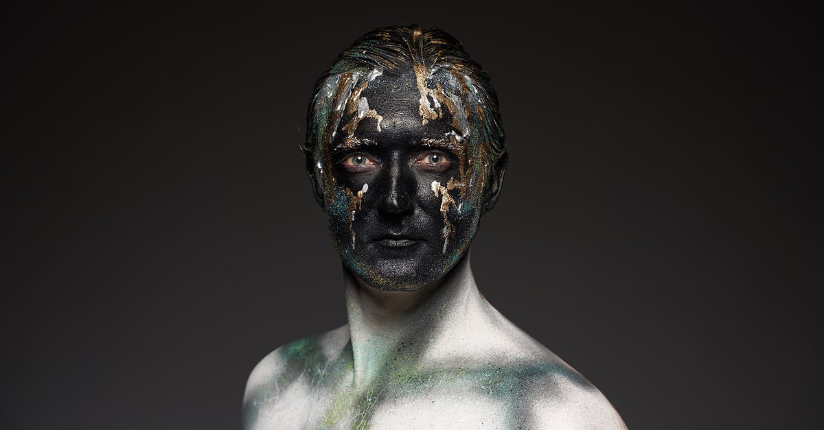 Zoom actor in while background out? How is this effect called and made? - Male shirtless model with glowing glitters on black painted face covering eyes standing on black backdrop